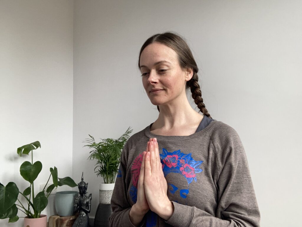 Image of woman with hands in atmanjali mudra, gratitude hand gesture, cultivating positive thought