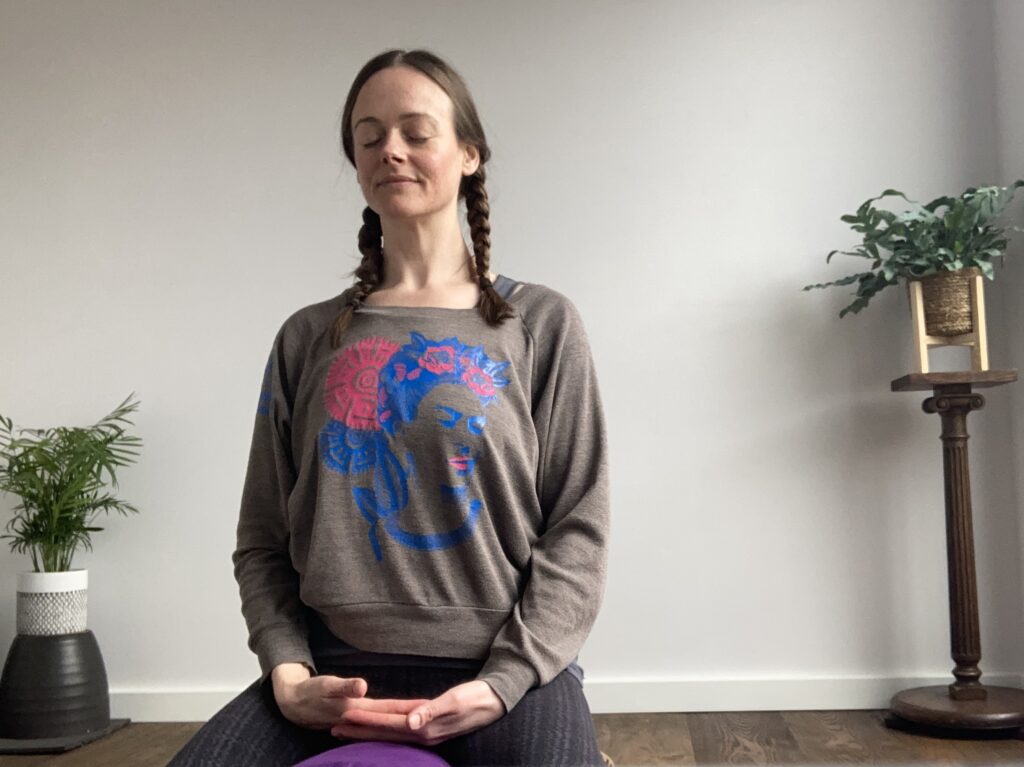 Image of woman sat in mindfulness-based meditation as a practice towards cultivating positive thought